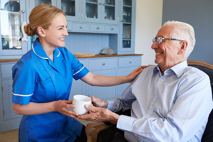 Nurse Giving Senior Man Cup Of Tea