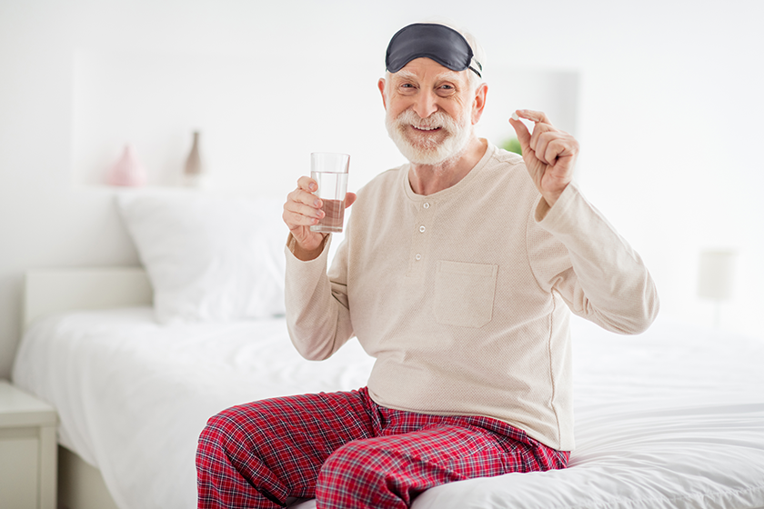 photo-of-pretty-attractive-age-pensioner-sleepwear-sitting-bed-drinking-water-medicine